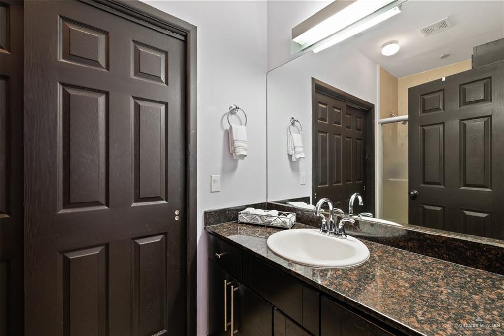 813 Travis Street, Unit 203 Mission, TX 78572 - Photo 14 of 30 a bathroom with a granite countertop sink and a mirror