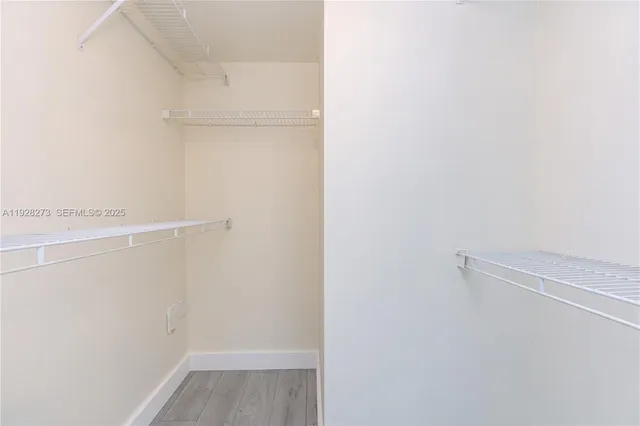 a view of walk in closet with empty racks