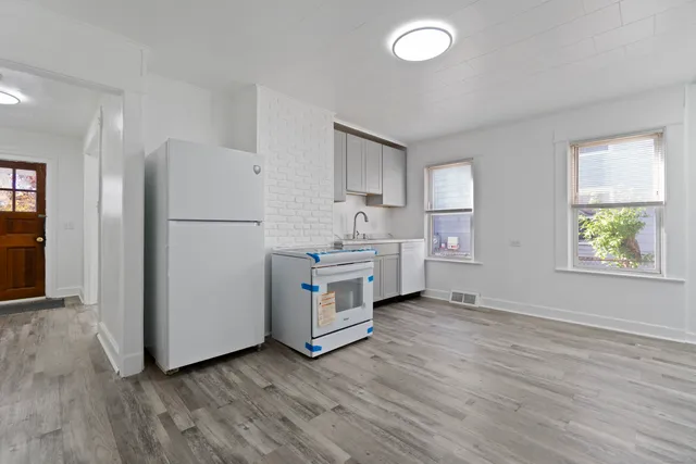 a kitchen with wooden floors and white appliances