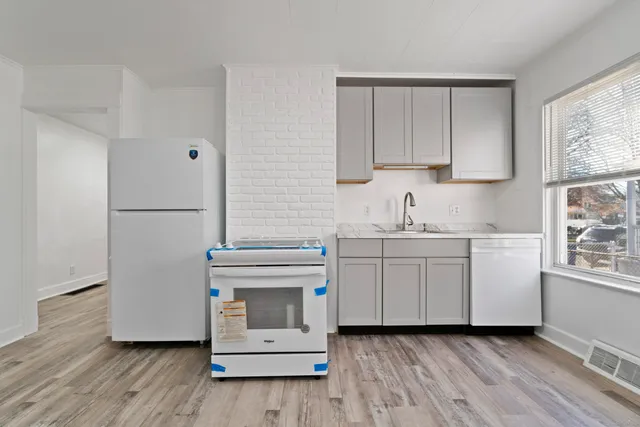 a kitchen with white cabinets and white appliances