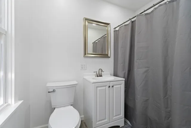 a bathroom with a toilet a sink and mirror