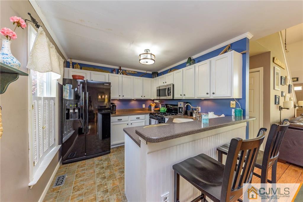 105 Quadrant Road Manahawkin, NJ 08050 - Photo 8 of 25 a kitchen with a refrigerator and a stove top oven