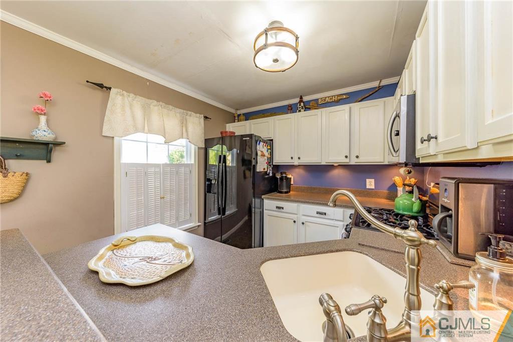105 Quadrant Road Manahawkin, NJ 08050 - Photo 9 of 25 a kitchen with a refrigerator and a stove