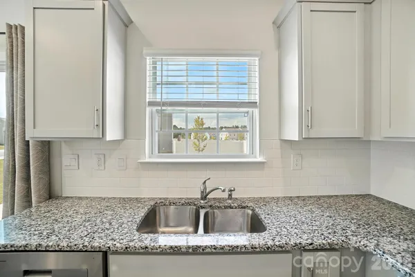 a kitchen with granite countertop a sink and a window