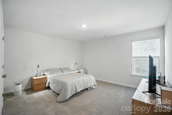 a spacious bedroom with a bed and wooden floor