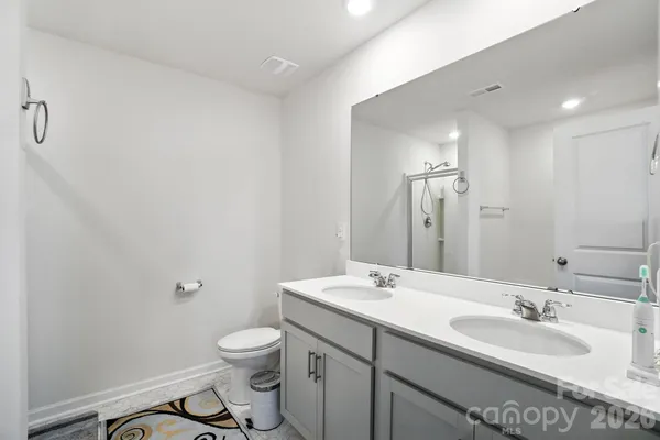 a bathroom with a granite countertop sink a toilet and a mirror