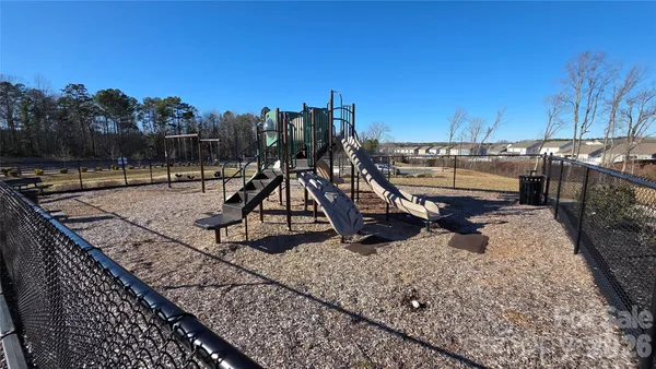 a sign board with a play ground in the back