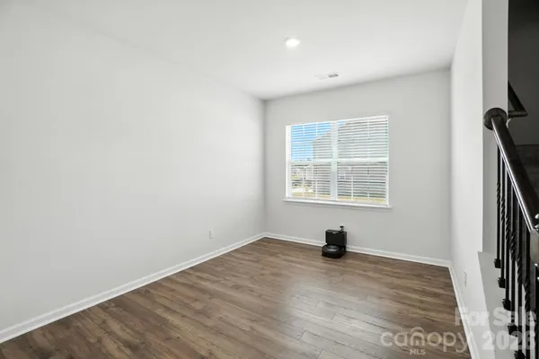 a view of empty room with wooden floor and window