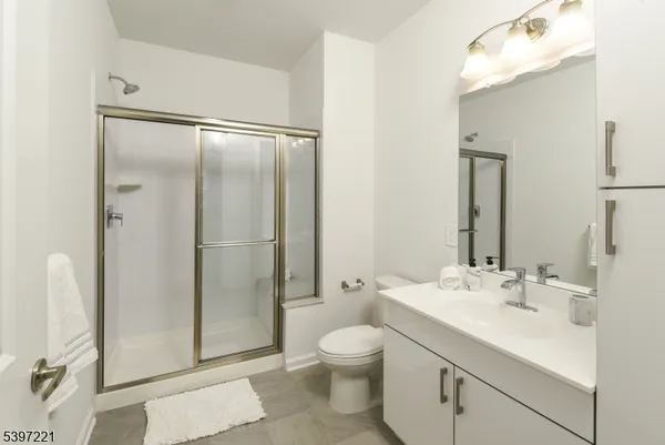 a bathroom with a shower sink mirror and toilet