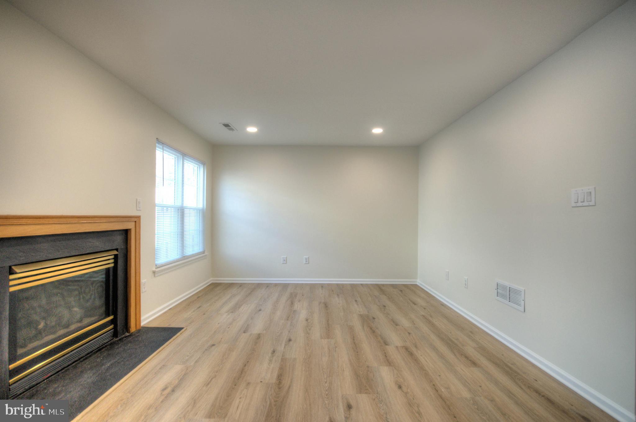 18 Alexandra Court Marlton, NJ 08053 - Photo 11 of 41 an empty room with wooden floor fireplace and windows