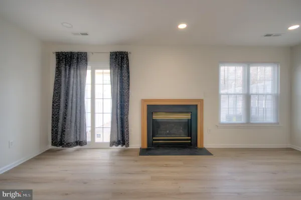 an empty room with windows and fireplace