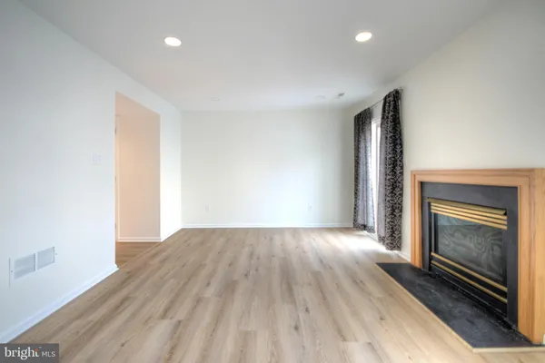 wooden floor in an empty room with a fireplace