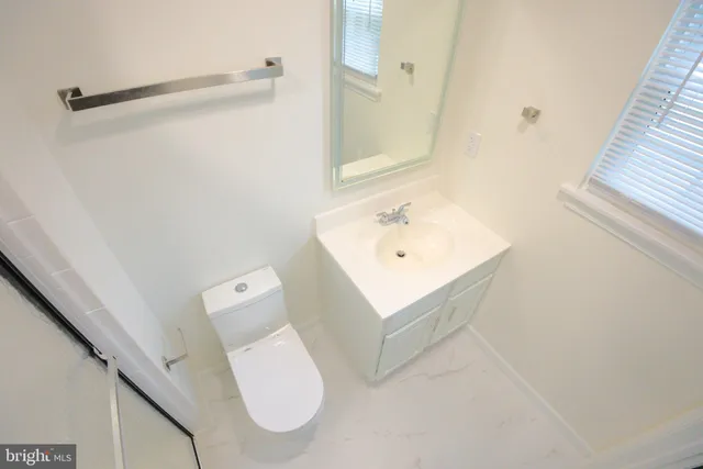 a bathroom with a toilet sink and mirror