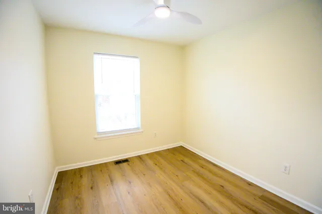 a view of a room with wooden floor and a window