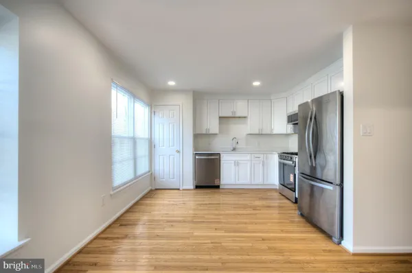 a kitchen with a refrigerator sink and wooden floor