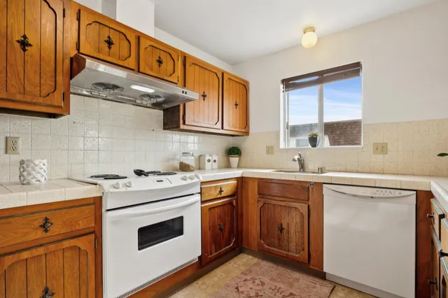 a kitchen with stainless steel appliances granite countertop a stove sink and cabinets