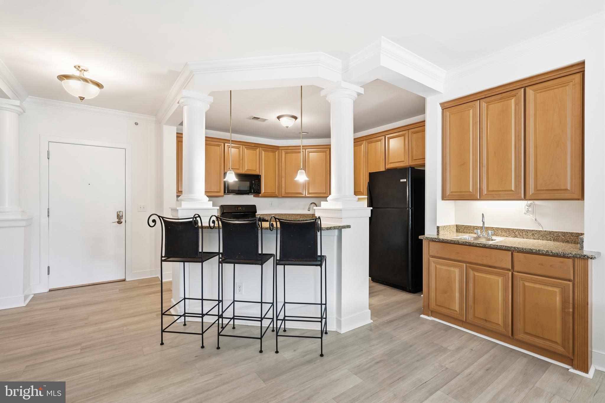 1333 Meridian Boulevard, Unit 1333 Warrington, PA 18976 - Photo 7 of 25 a kitchen with stainless steel appliances kitchen island granite countertop a refrigerator a stove a sink dishwasher and white cabinets with wooden floor