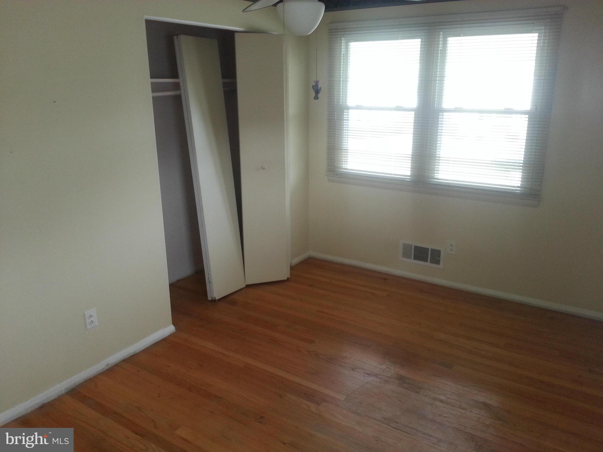 6707 Fordcrest Road Baltimore, MD 21237 - Photo 11 of 21 an empty room with wooden floor and windows