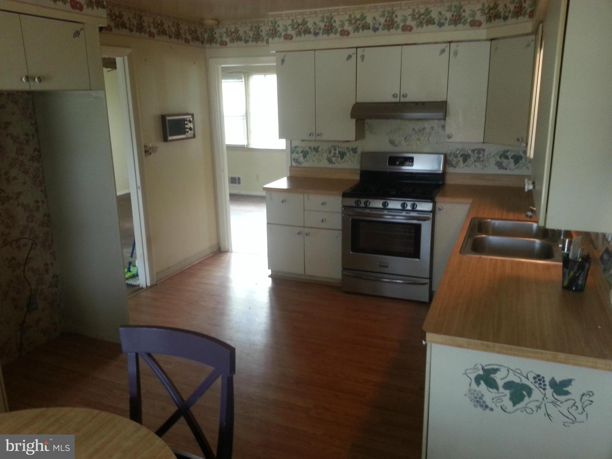 6707 Fordcrest Road Baltimore, MD 21237 - Photo 6 of 21 a kitchen with a wooden floor and a stove top oven