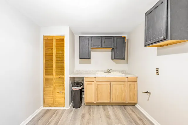 a kitchen with a sink and wooden floor
