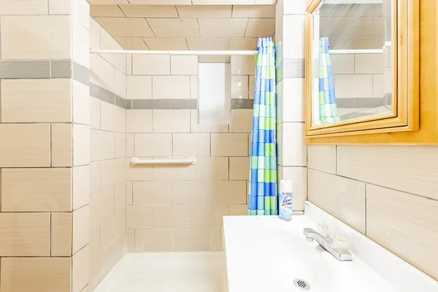 a view of a livingroom with a chandelier fan and kitchen view