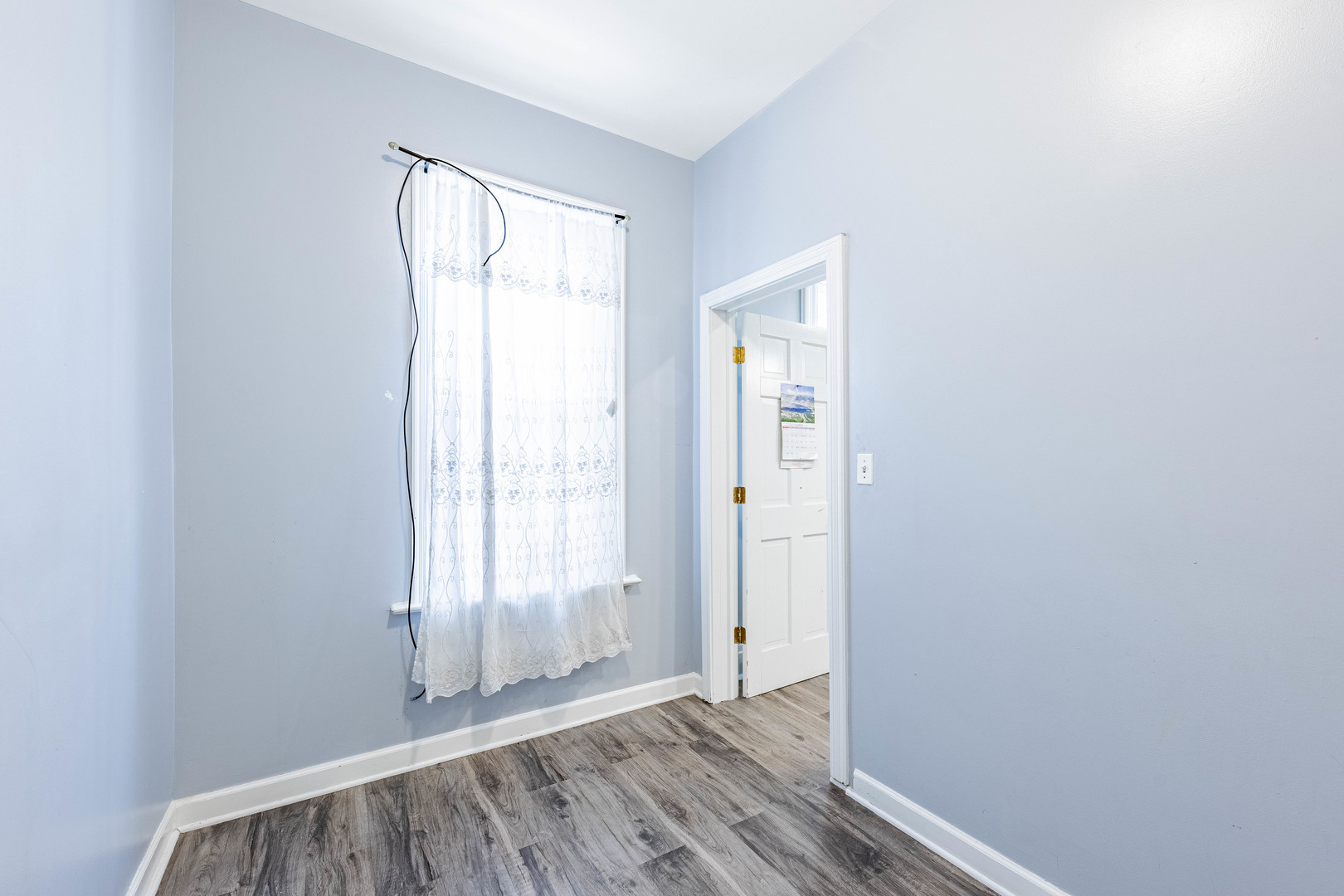3022 South Homan Avenue Chicago, IL 60623 - Photo 20 of 29 a view of an empty room with wooden floor and a window