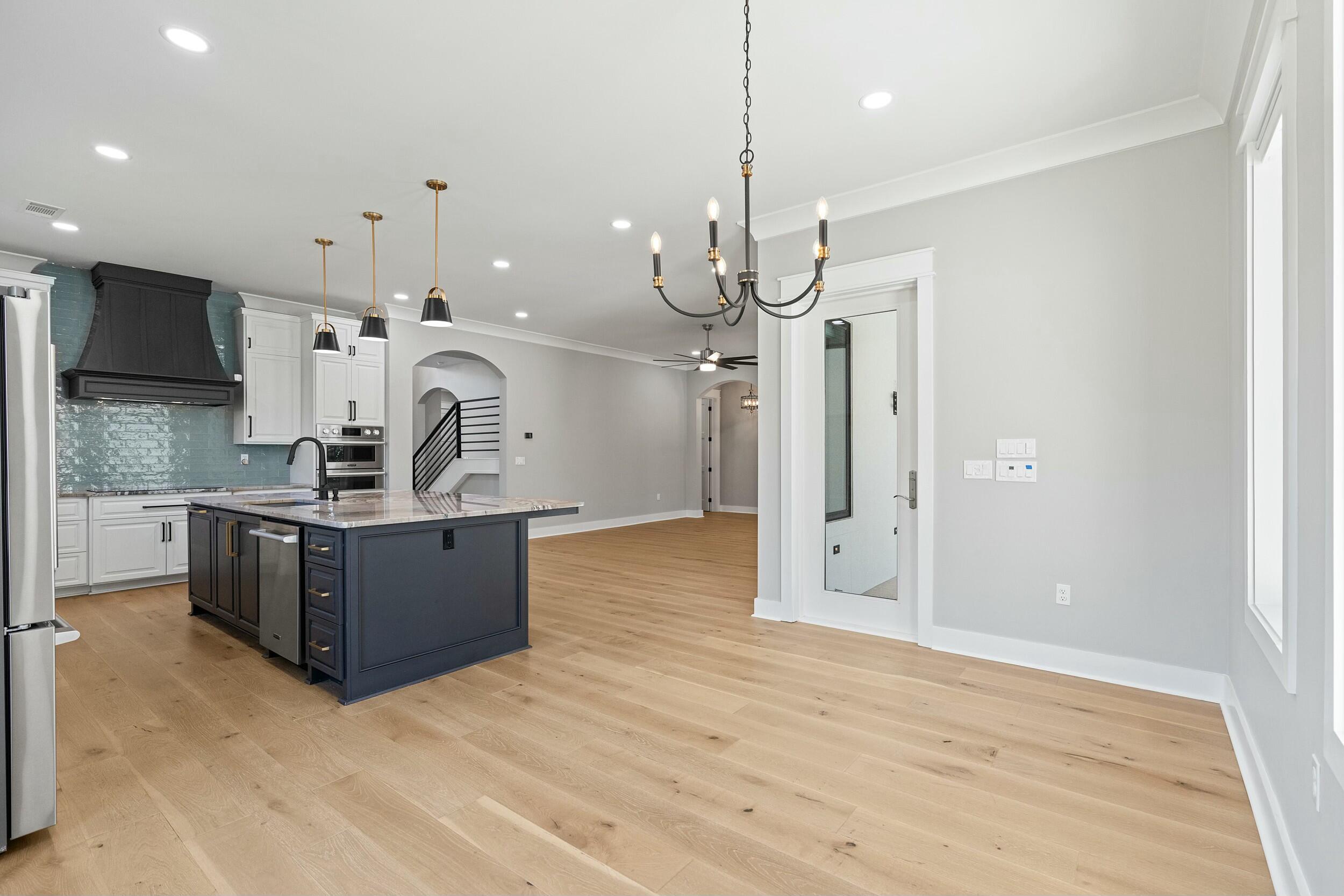 198 Emerald Ridge Santa Rosa Beach, FL 32459 - Photo 23 of 66 a kitchen with stainless steel appliances kitchen island a refrigerator and a wooden floor