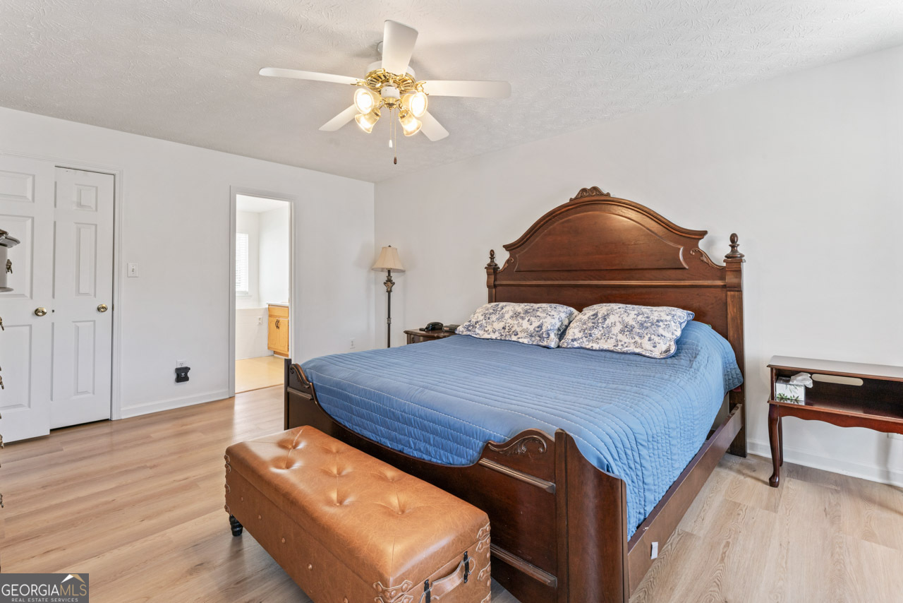 111 Cardell Farms Road Locust Grove, GA 30248 - Photo 18 of 37 a bedroom with a bed and a chandelier