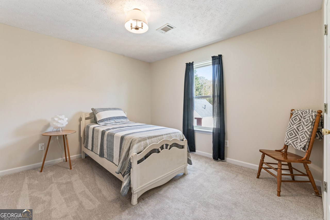 111 Cardell Farms Road Locust Grove, GA 30248 - Photo 24 of 37 a spacious bedroom with a bed and chair