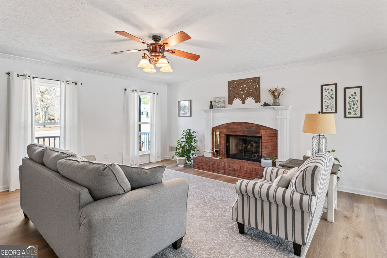 111 Cardell Farms Road Locust Grove, GA 30248 - Photo 8 of 37 a living room with furniture a fireplace and a flat screen tv