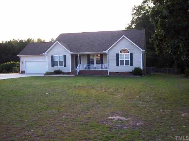 875 Bill Avery Road Coats, NC 27521 - Photo 1 of 8 a front view of a house with a garden and trees