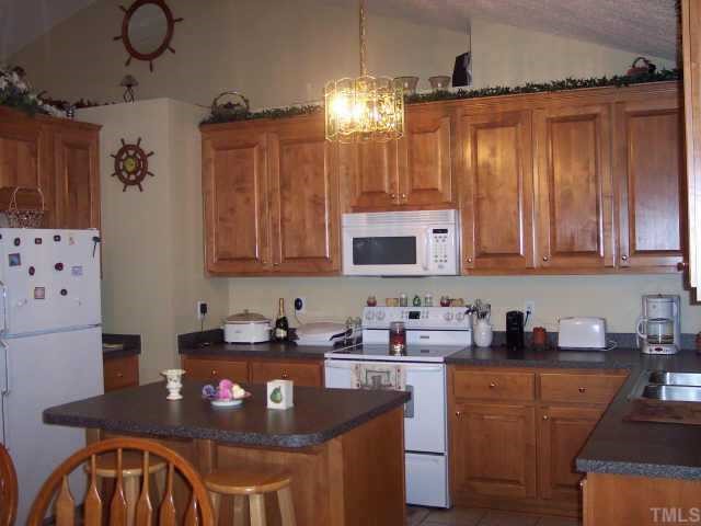 875 Bill Avery Road Coats, NC 27521 - Photo 3 of 8 a kitchen with granite countertop a sink a stove and cabinets