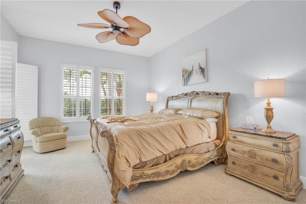 9006 Cascada Way, Unit 101 Naples, FL 34114 - Photo 16 of 25 a bedroom with a bed and a chandelier fan