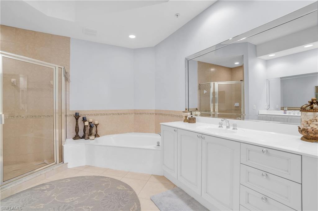 9006 Cascada Way, Unit 101 Naples, FL 34114 - Photo 18 of 25 a bathroom with a sink a toilet and a mirror