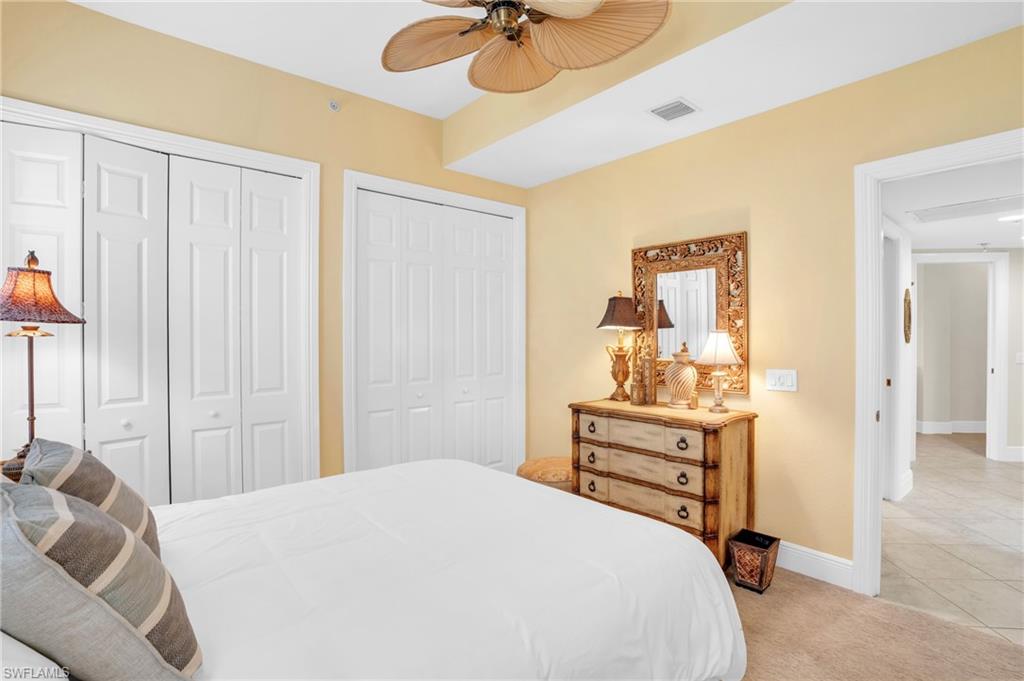 9006 Cascada Way, Unit 101 Naples, FL 34114 - Photo 19 of 25 a bedroom with a bed and a chandelier