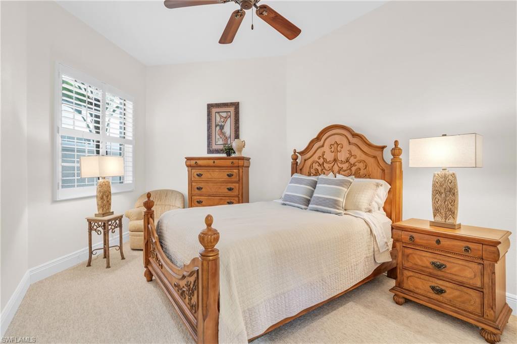 9006 Cascada Way, Unit 101 Naples, FL 34114 - Photo 21 of 25 a bedroom with a bed and a chandelier
