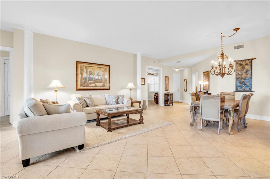 9006 Cascada Way, Unit 101 Naples, FL 34114 - Photo 5 of 25 a living room with furniture a dining table and a chandelier