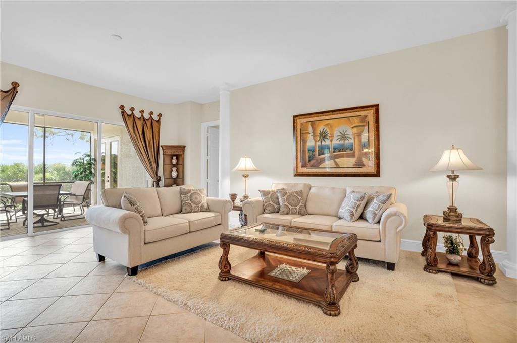 9006 Cascada Way, Unit 101 Naples, FL 34114 - Photo 6 of 25 a living room with furniture and a wooden floor