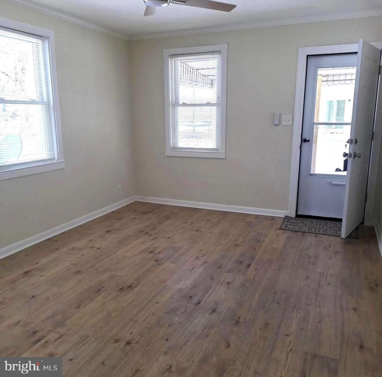403 Trenton Court Wallingford, PA 19086 - Photo 4 of 11 an empty room with wooden floor and windows
