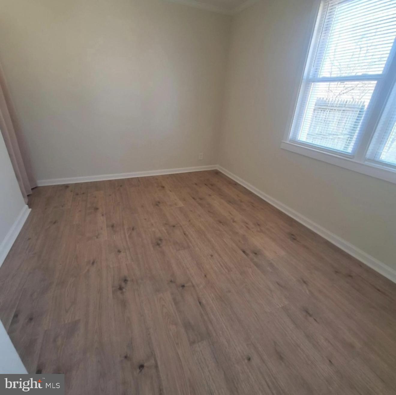 403 Trenton Court Wallingford, PA 19086 - Photo 7 of 11 an empty room with wooden floor and windows