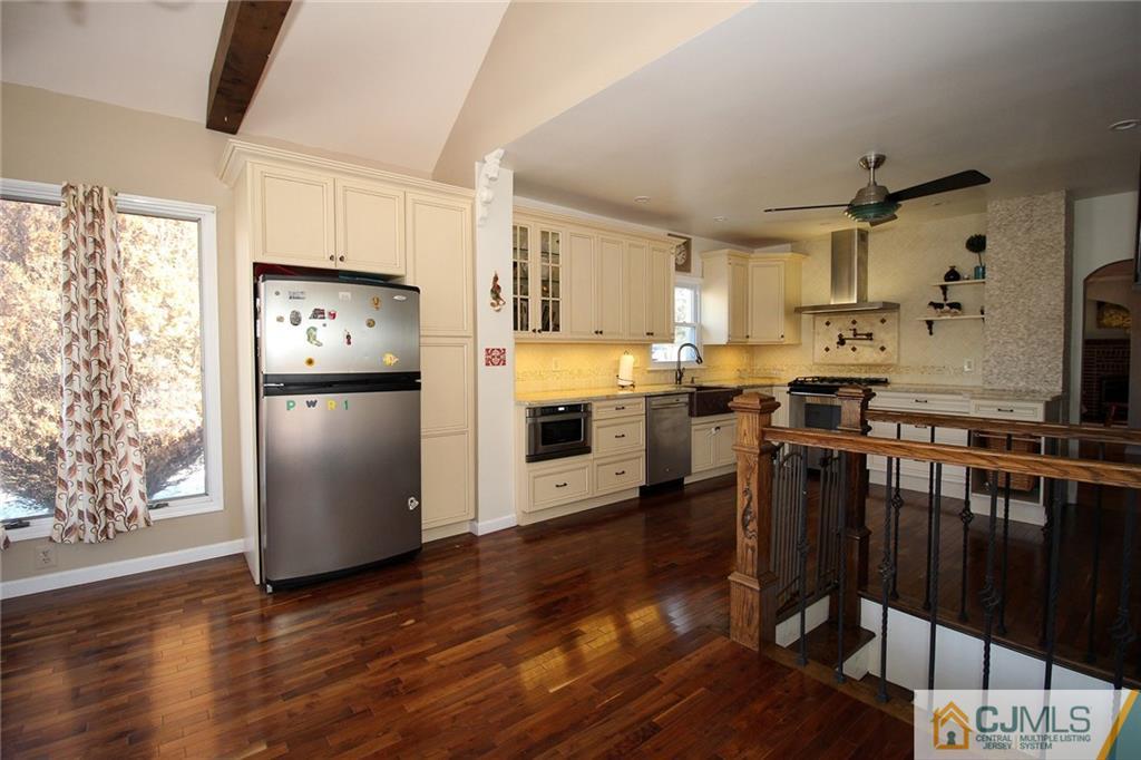 130 Ethel Road Edison, NJ 08817 - Photo 8 of 25 a kitchen with stainless steel appliances a refrigerator a stove a sink dishwasher and wooden cabinets with wooden floor
