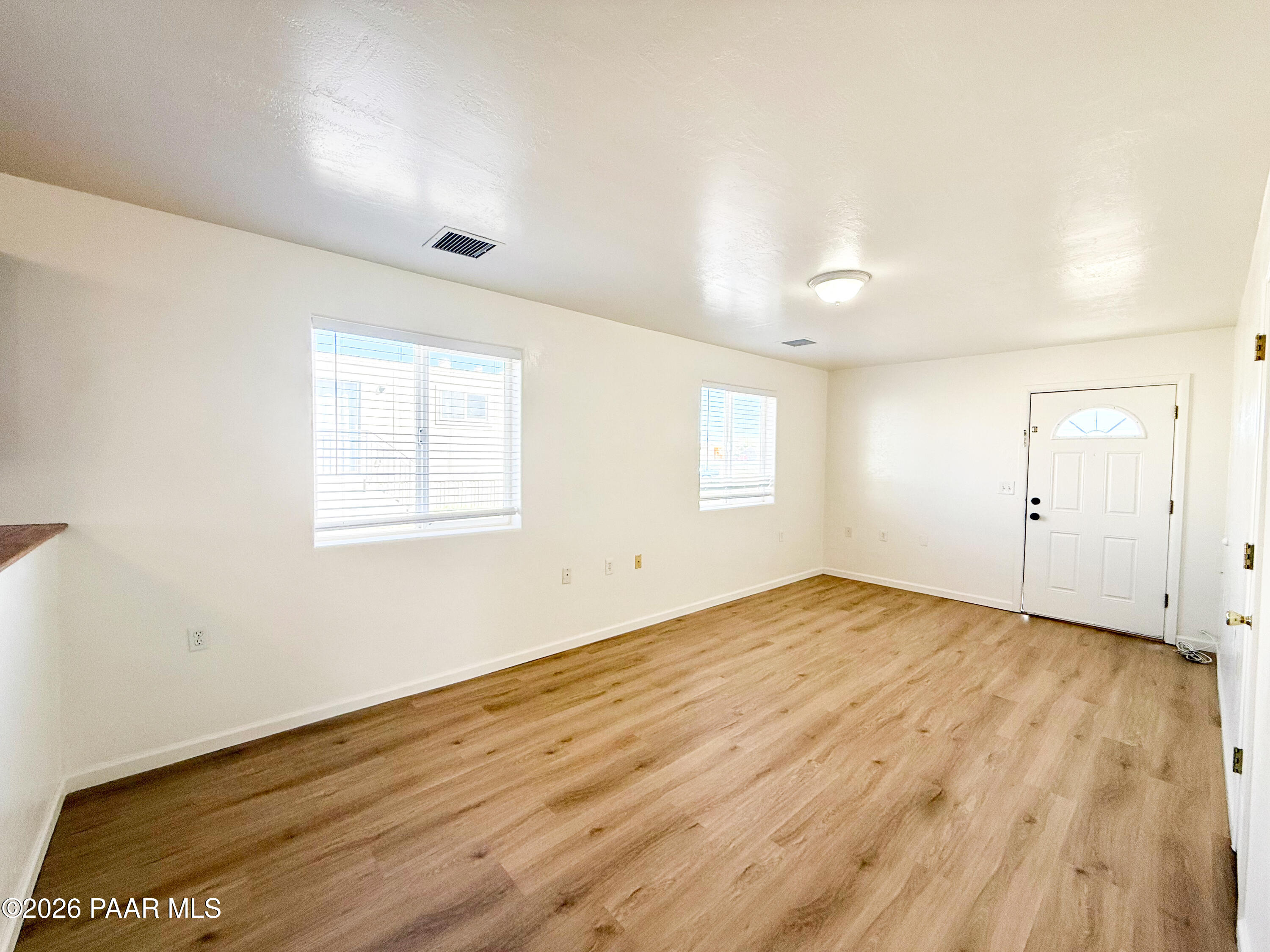 430 West Lake Louise Road Paulden, AZ 86334 - Photo 2 of 19 an empty room with wooden floor and windows