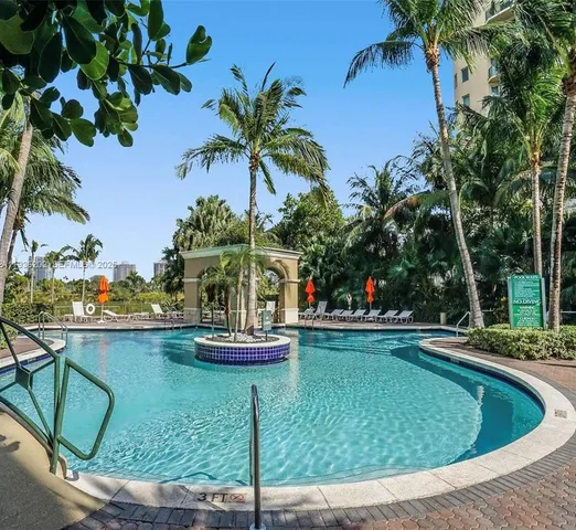 a view of a swimming pool with a lawn chairs under an umbrella