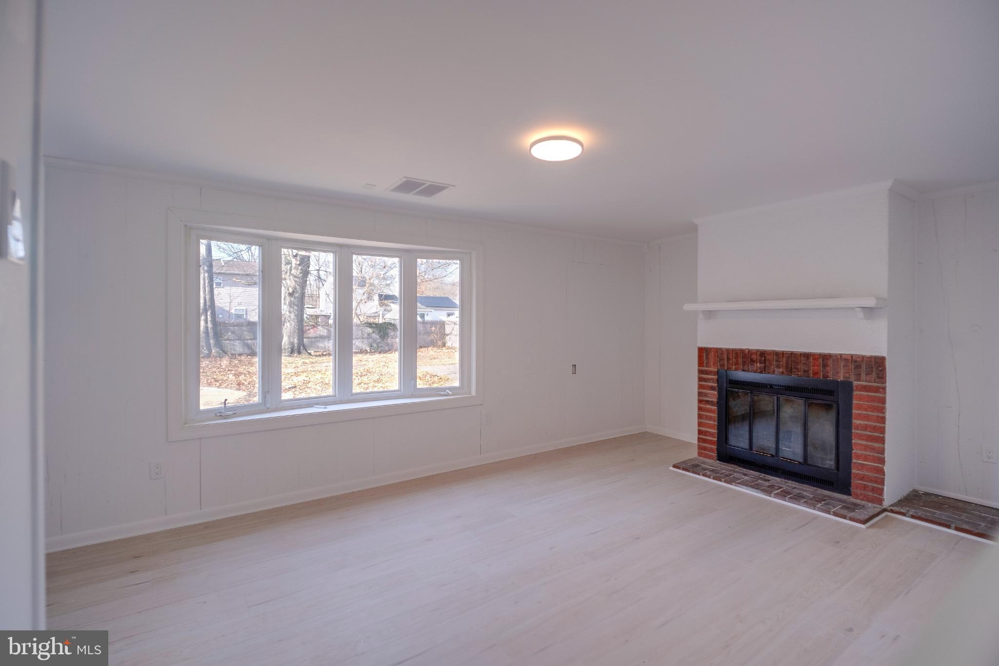 1302 Edgewood Avenue Westville, NJ 08093 - Photo 14 of 16 an empty room with a fireplace and window