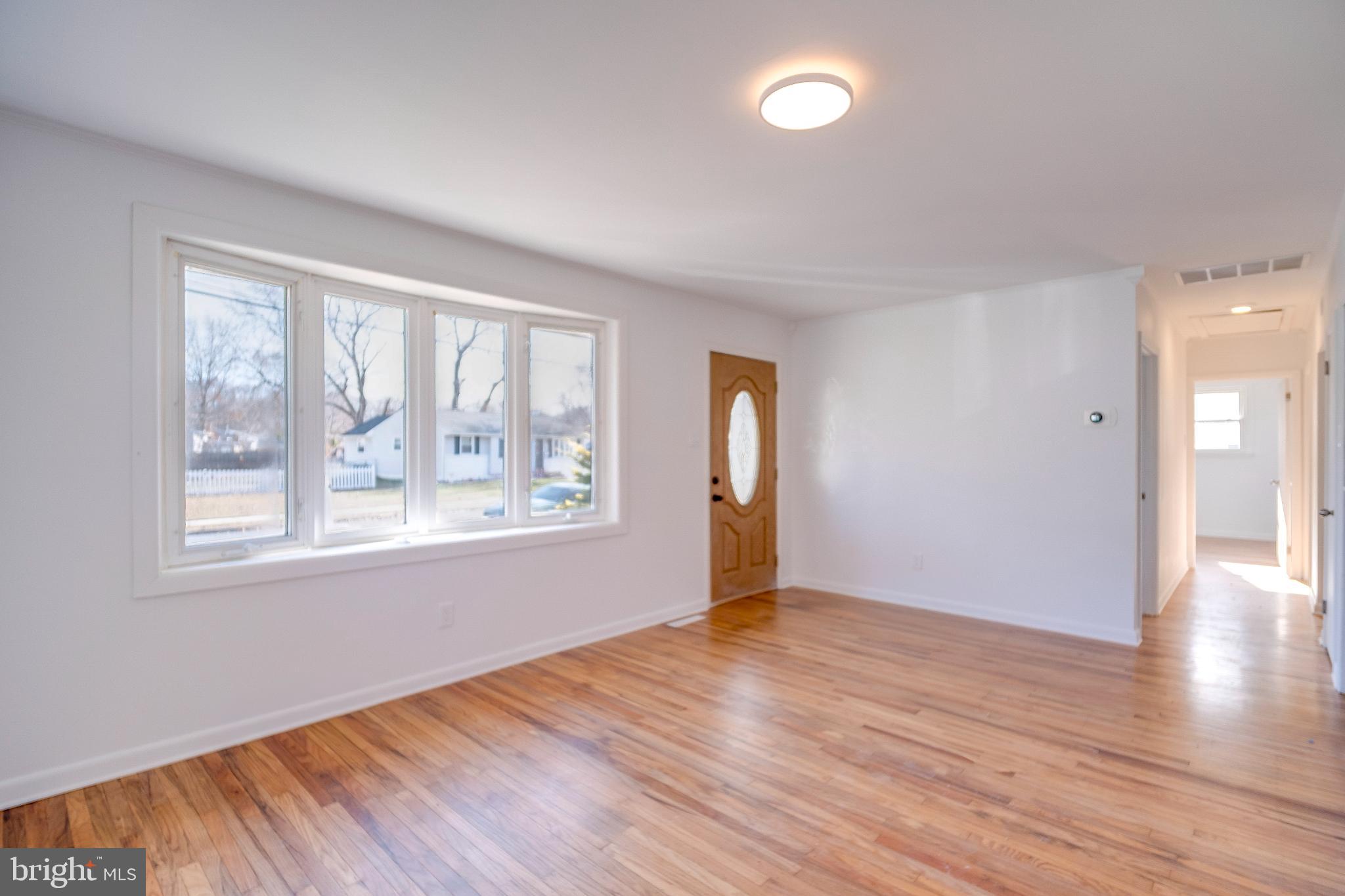 1302 Edgewood Avenue Westville, NJ 08093 - Photo 4 of 16 a view of an empty room with wooden floor and a window