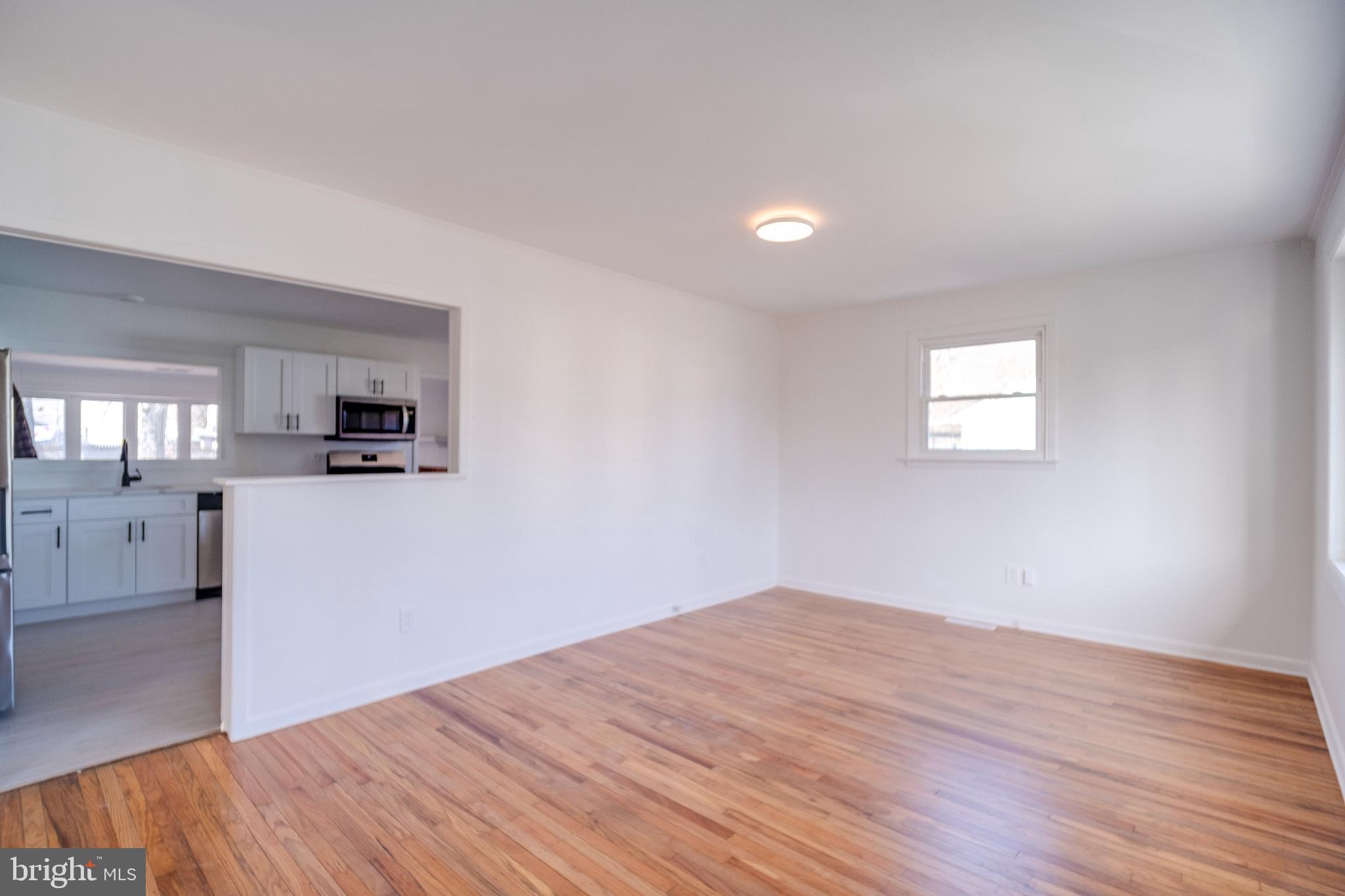 1302 Edgewood Avenue Westville, NJ 08093 - Photo 5 of 16 a big room with wooden floor and a kitchen