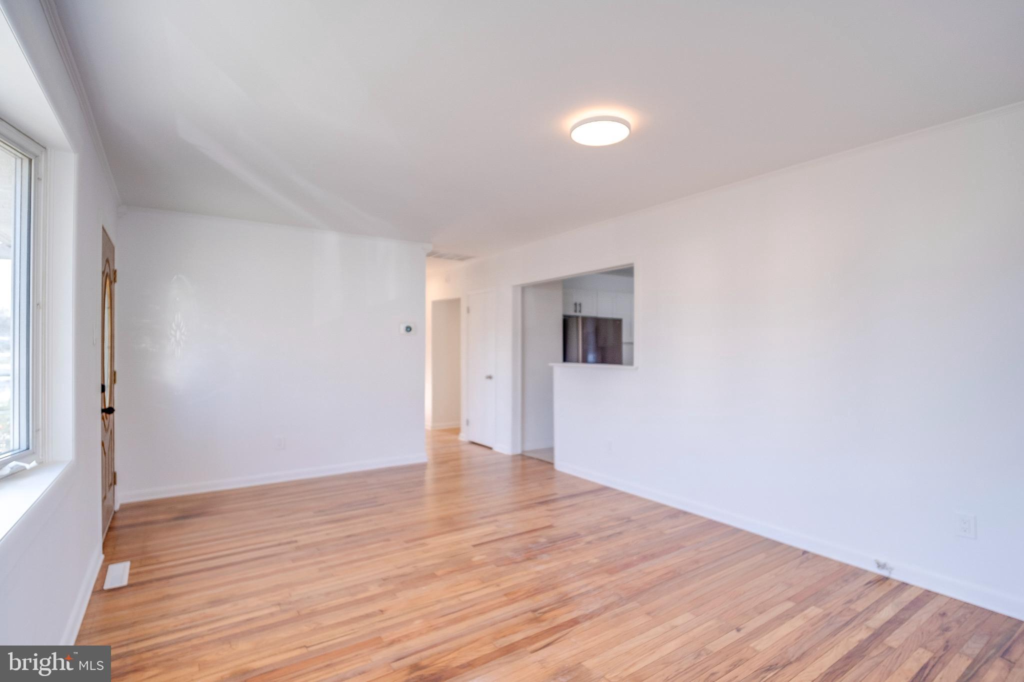 1302 Edgewood Avenue Westville, NJ 08093 - Photo 6 of 16 a view of an empty room with wooden floor and a window