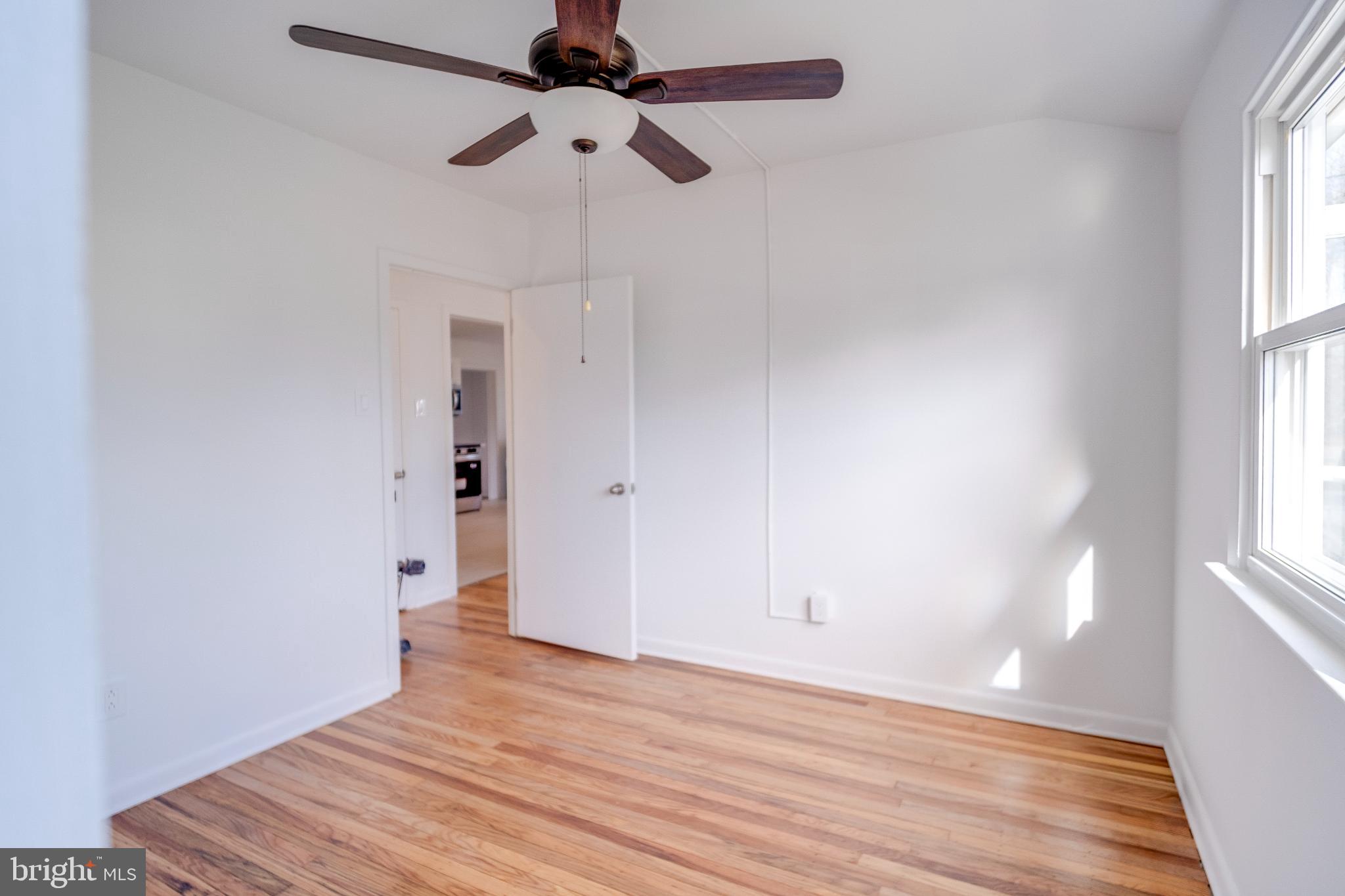 1302 Edgewood Avenue Westville, NJ 08093 - Photo 10 of 16 a view of an empty room with wooden floor and a window
