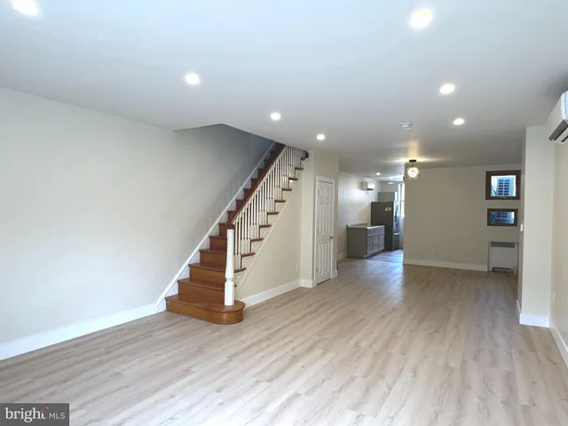 a view of a hallway with wooden floor and stairs