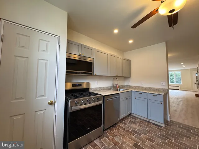 a kitchen with stainless steel appliances granite countertop a sink and stove top oven
